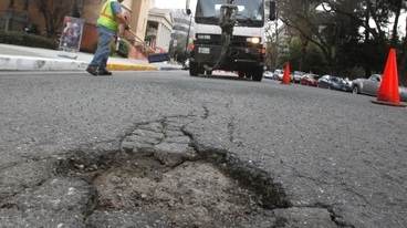 A pothole forming in the street.