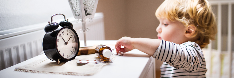 A small Child reaching for medicine on a table.