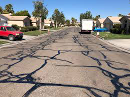 A street with many twisted and interconnected cracks sealed with black asphalt