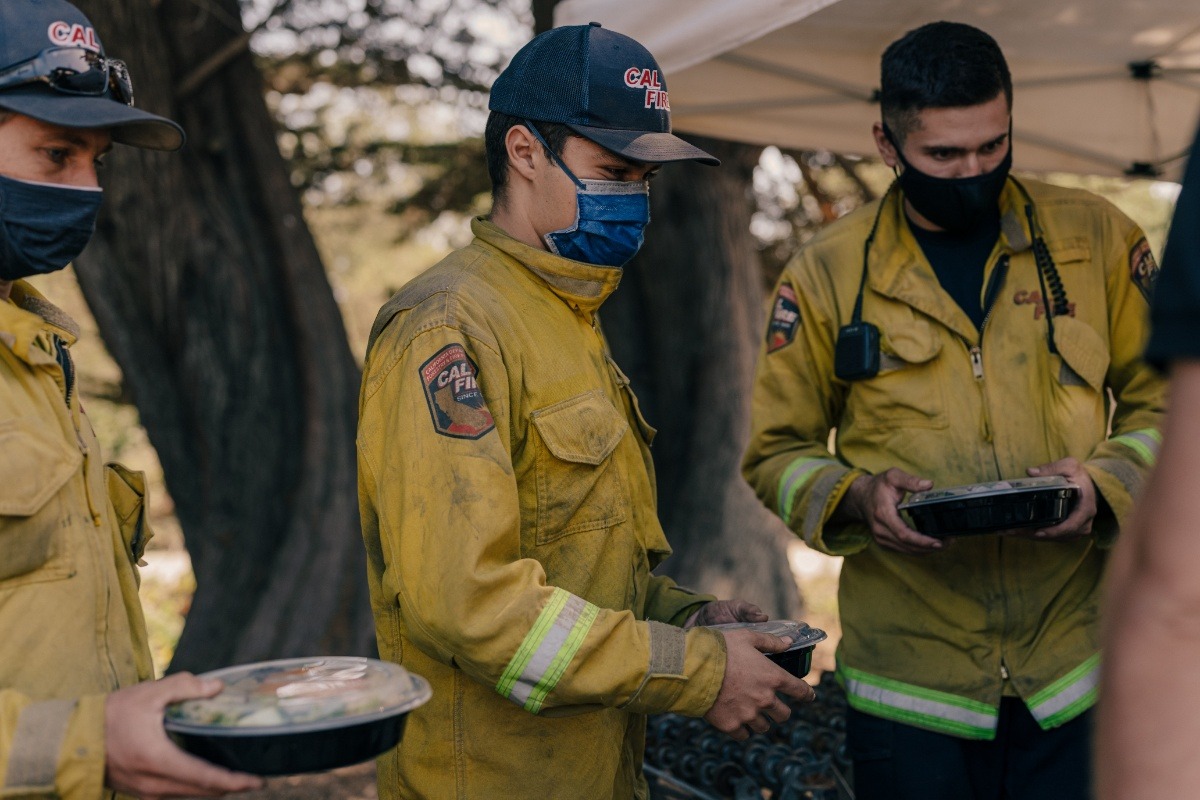 Firefighters holding meals from Off the Grid