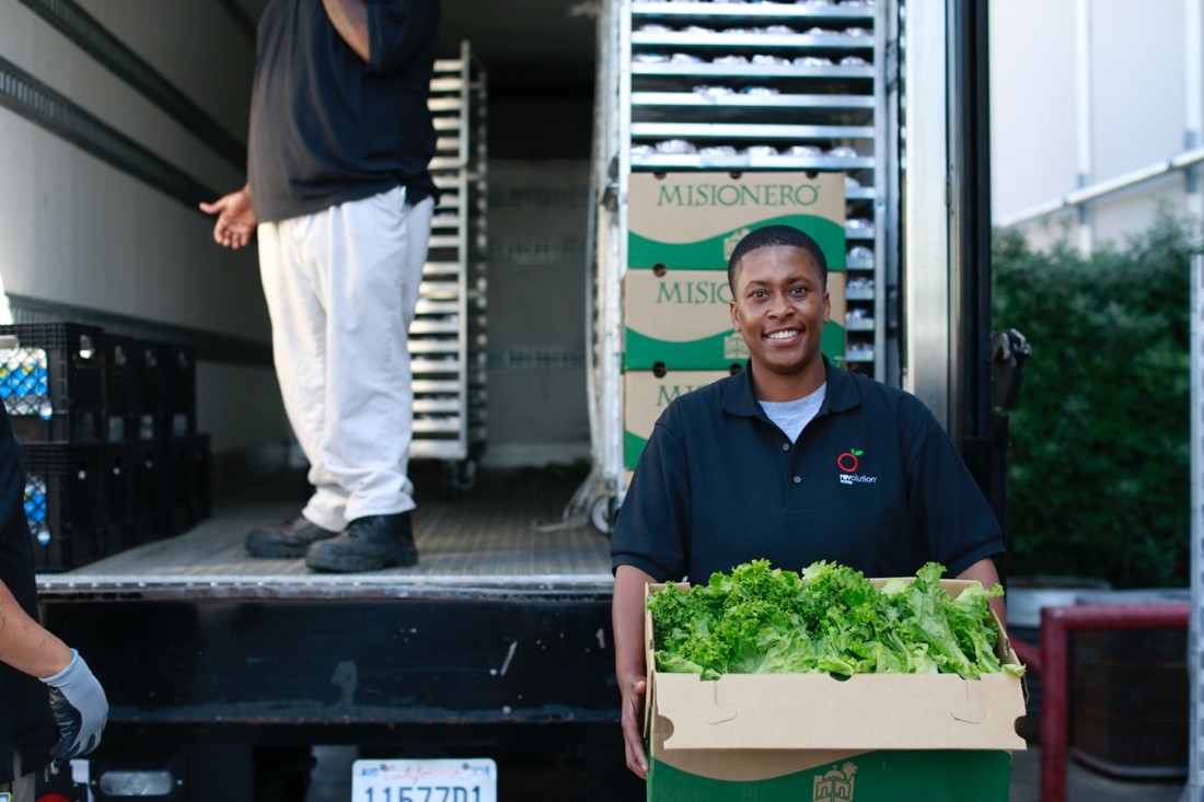 Revolution Food workers packaging fresh produce.