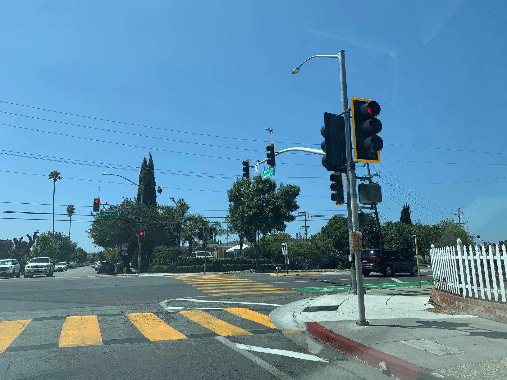 An intersection with pedestrian and bicycle safety improvements including high visibility crosswalk and reflective frames around the traffic signals