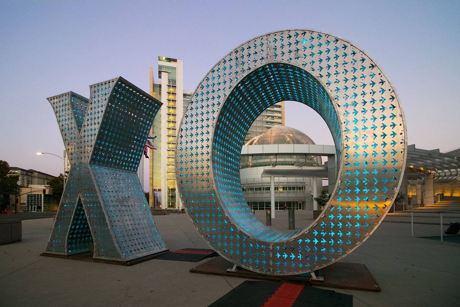 Image of XO Sculpture in front of City Hall the X and the O are both 12 feet tall and illuminated in blue