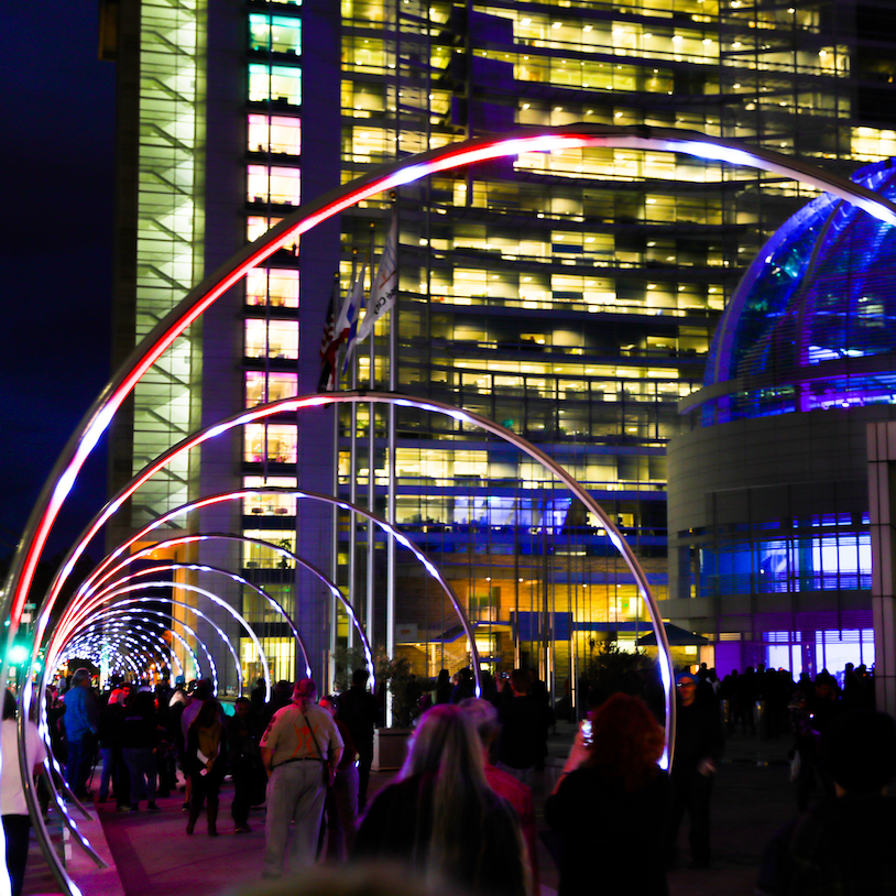 Sonic Runway at night in front of City Hall with people enjoying the music and patterns on the light rings