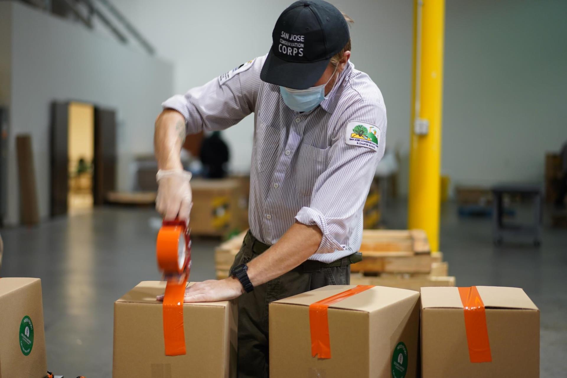 SJ Conservation Corps member packaging boxes for food distribution