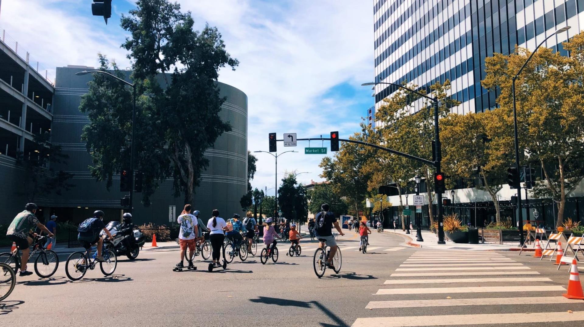 Image of people walking and biking in a downtown intersection closed to car traffic