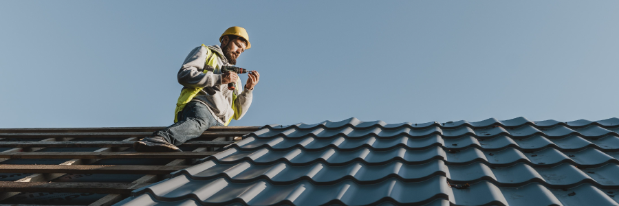 A construction worker installing a new roof on a home.