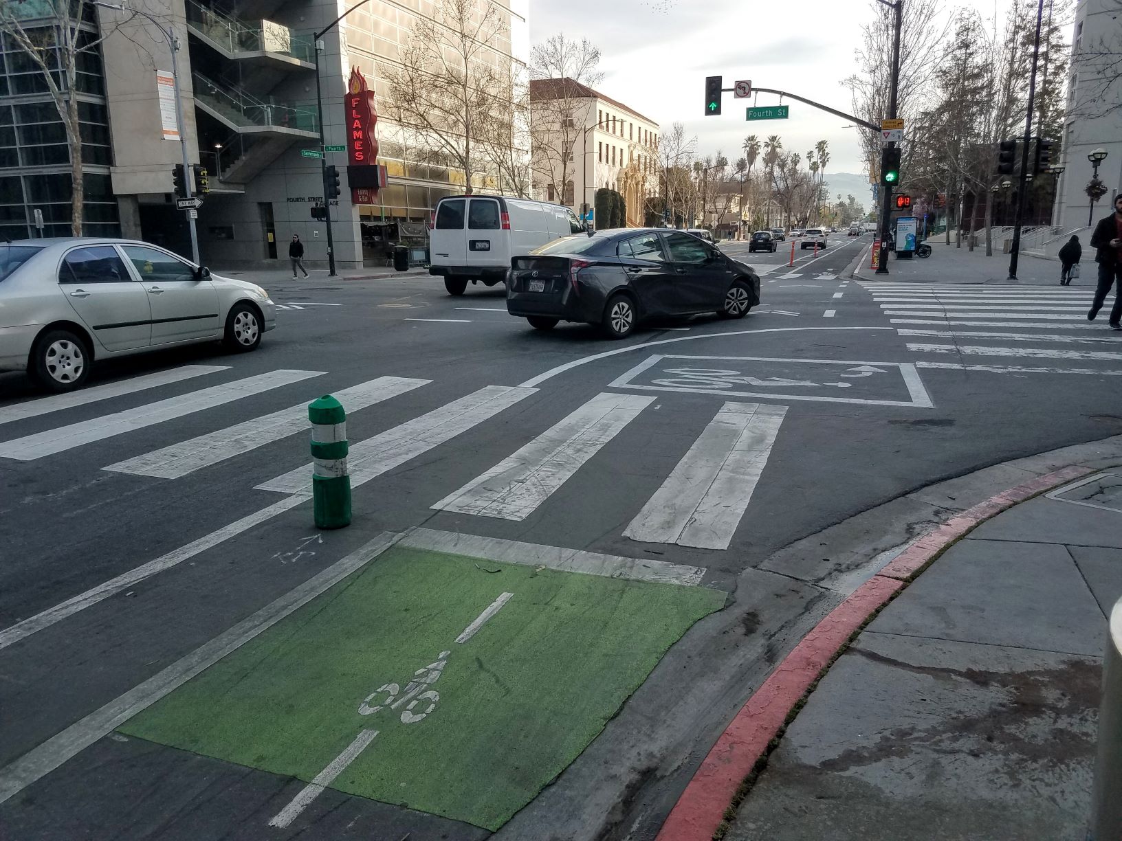 A car turning right across a crosswalk and bike lane