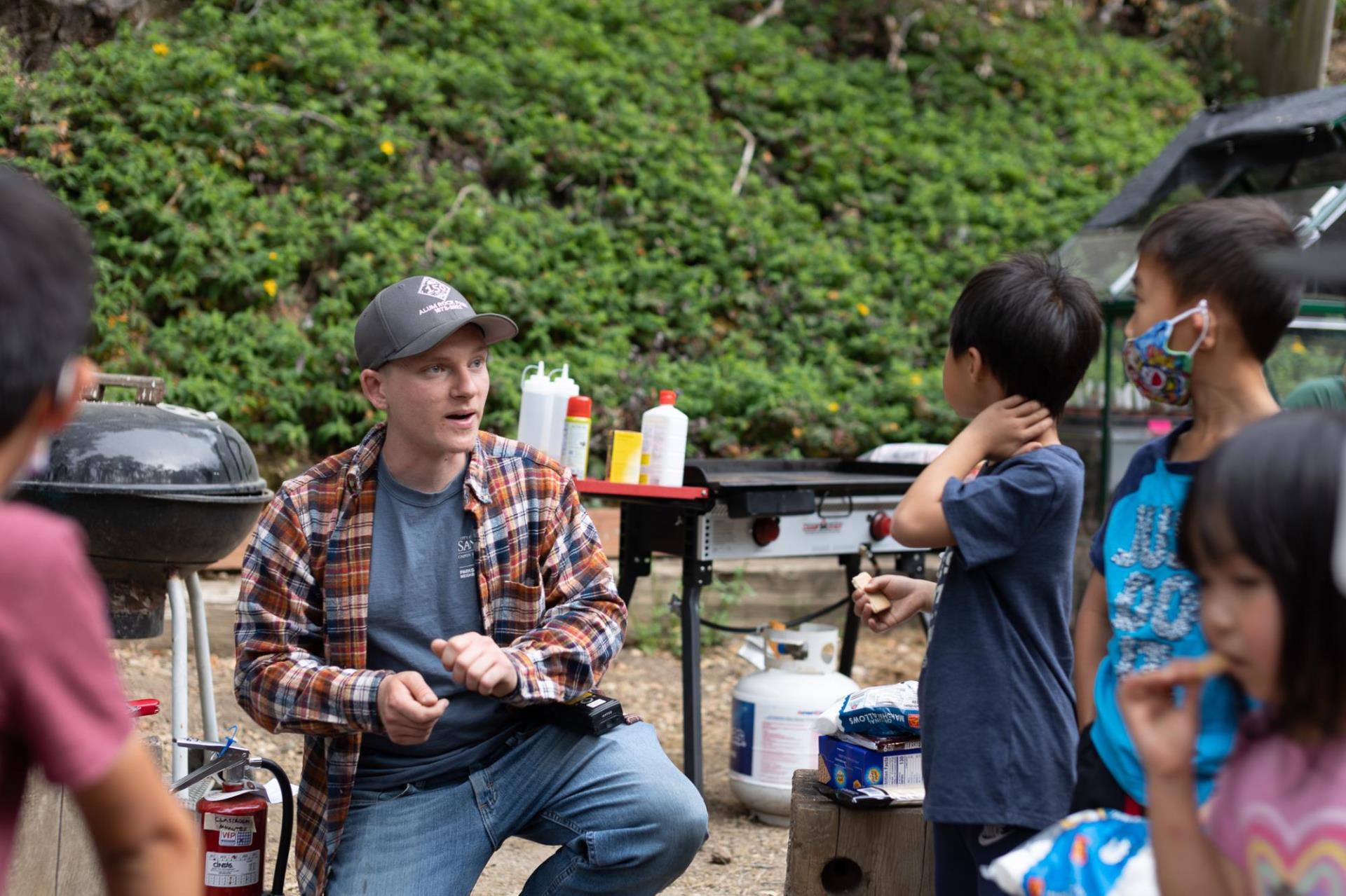 Alum Rock Park staff, Noah Rouleau, shows camp participants how to start and build a safe camp fire.