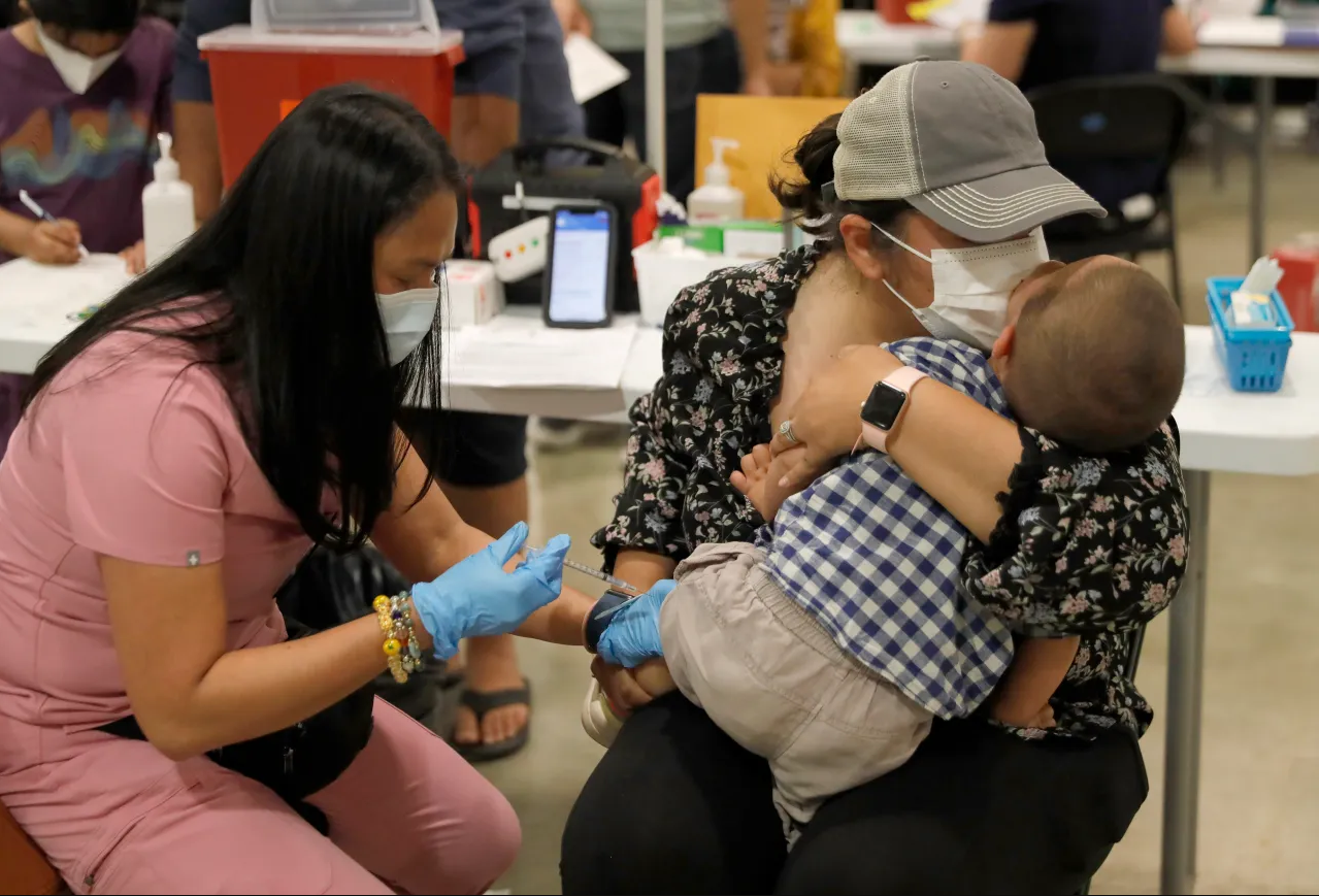 Mother comforting her son as he receives his COVID-19 Vaccination