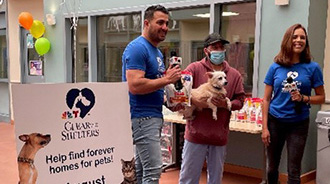 Animal Adoption Event at the San José Animal Shelter with three people standing next to a poster for the event