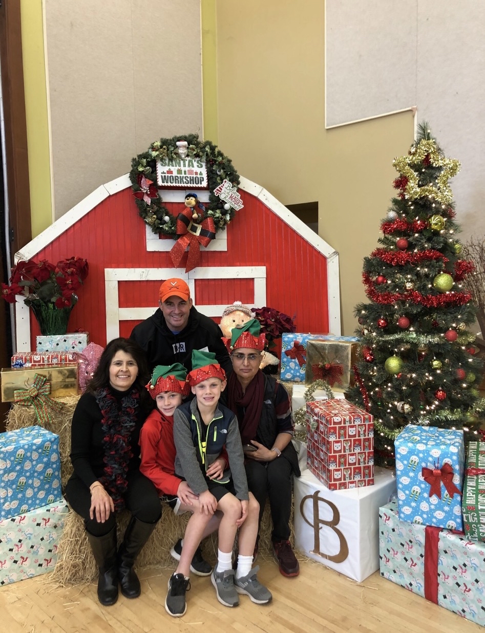 Patricia Rivera poses for a picture with a family at Emma Prusch Park's annual holiday event