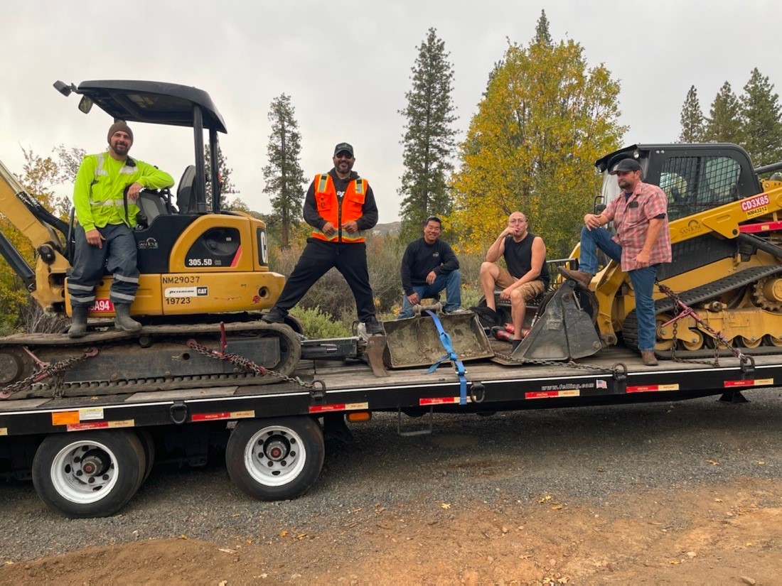 Capital Infrastructure Team poses for a photo with heavy equipment