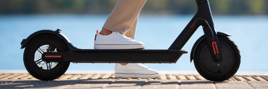 A close-up of a woman riding an electric scooter