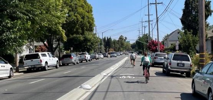 Two people riding bikes in a frontage lane