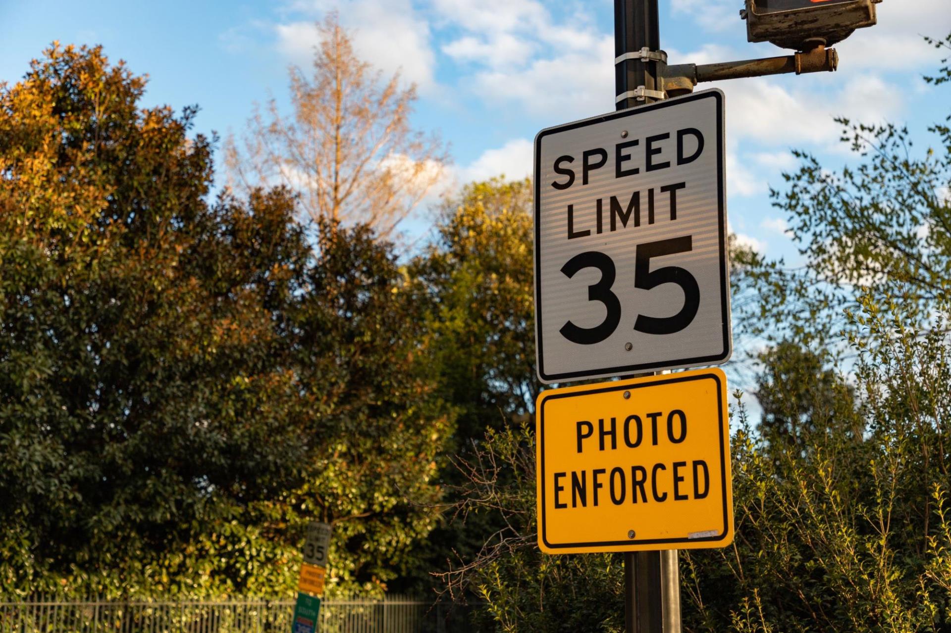 A 35 MPH speed limit sign above a sign that says photo enforced