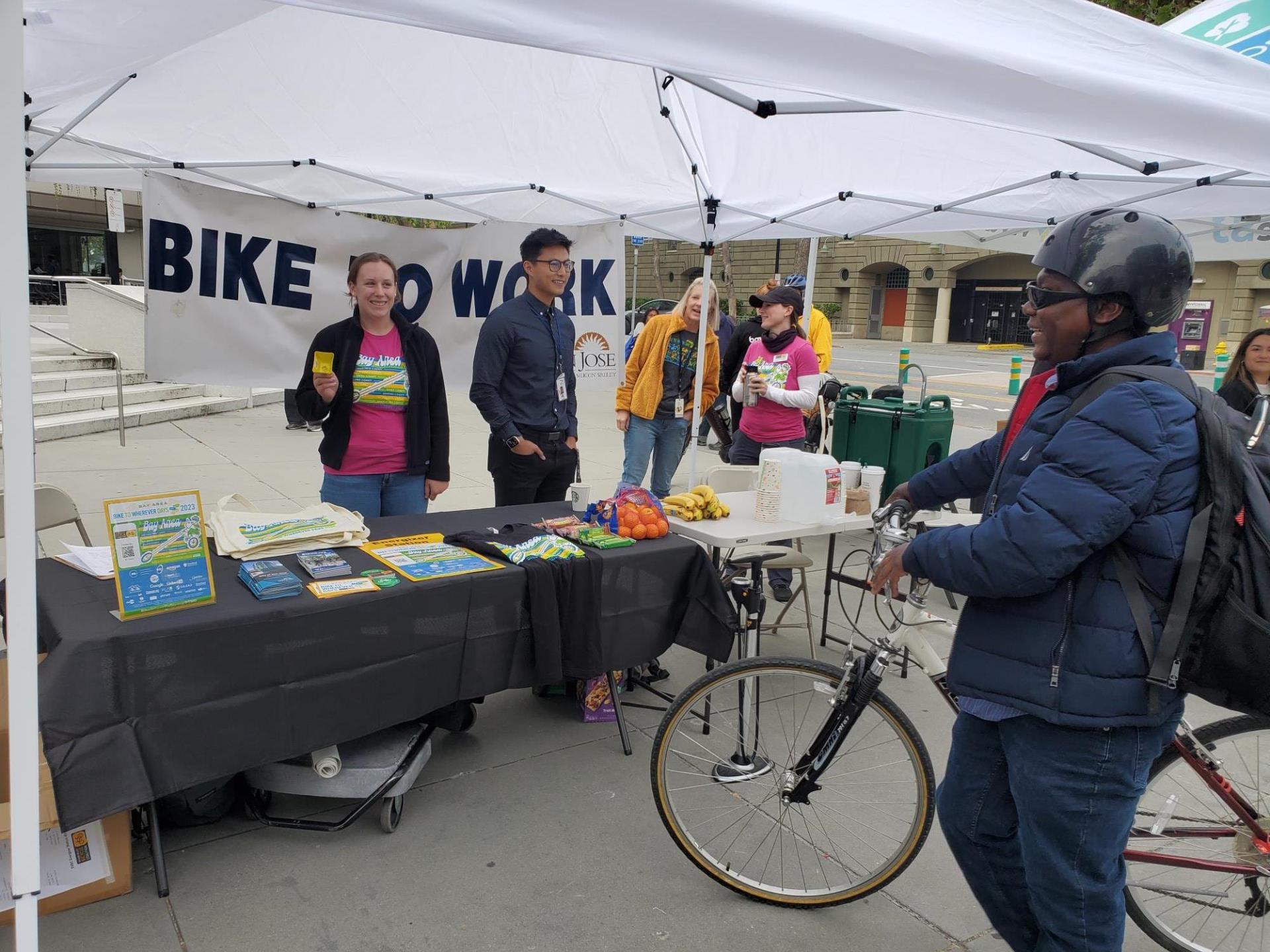 Department of Transportation employees talking with a bicyclist at the City's Energizer Station