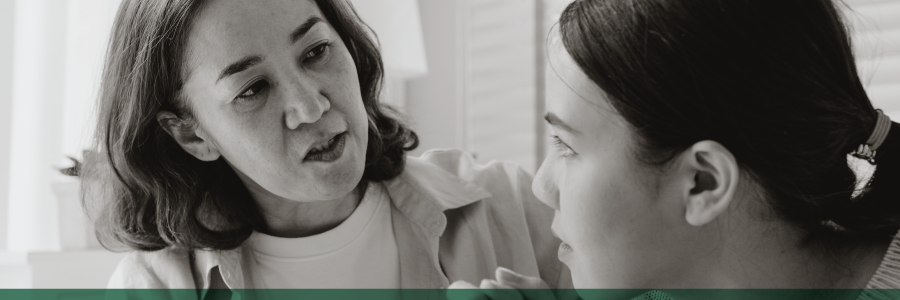 A mother speaking with her daughter at home.