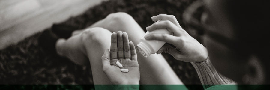 A woman putting pills into her hand.