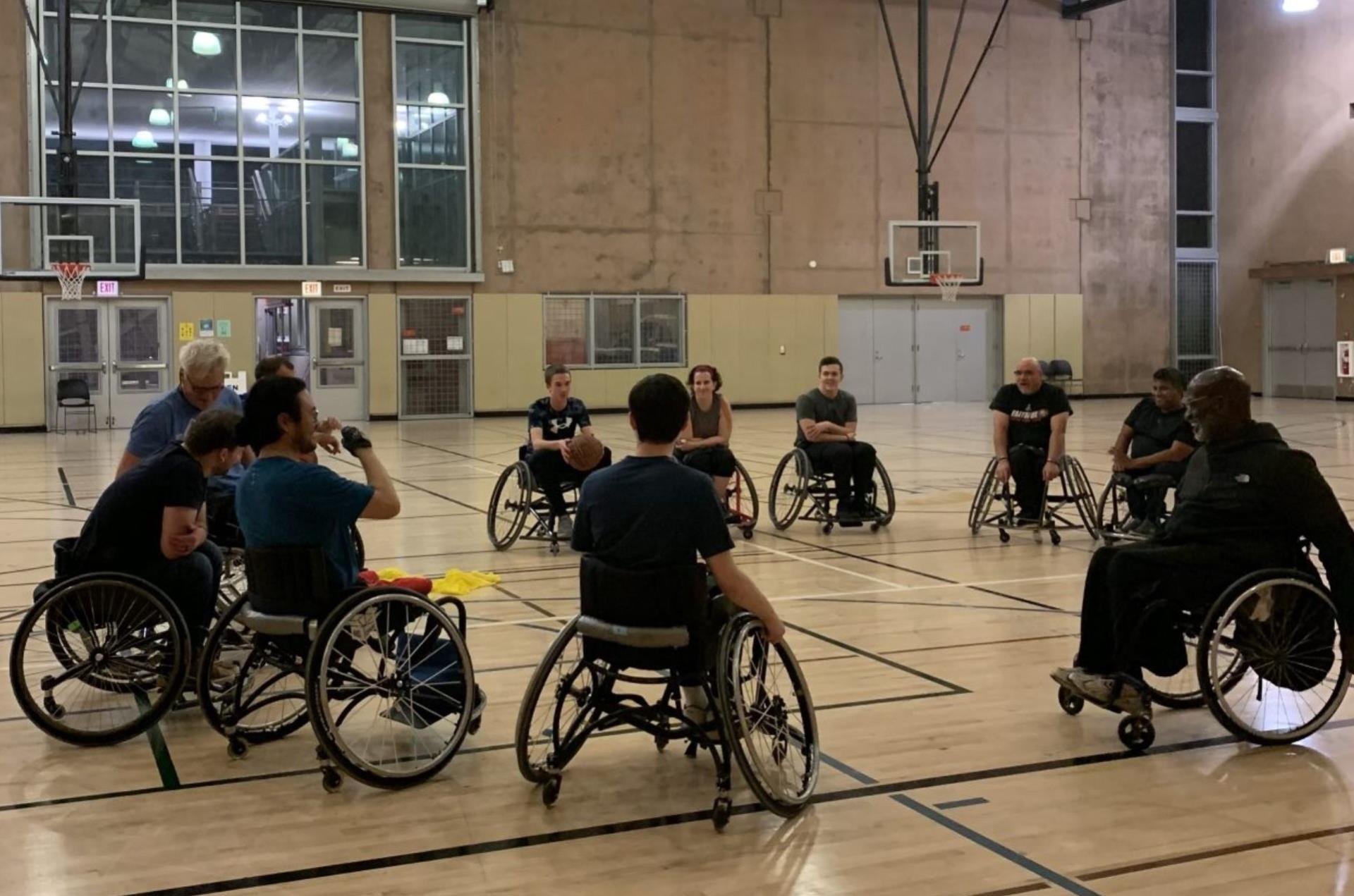 Power soccer players in powered wheelchairs move the soccer ball towards the goal and around defensive players.