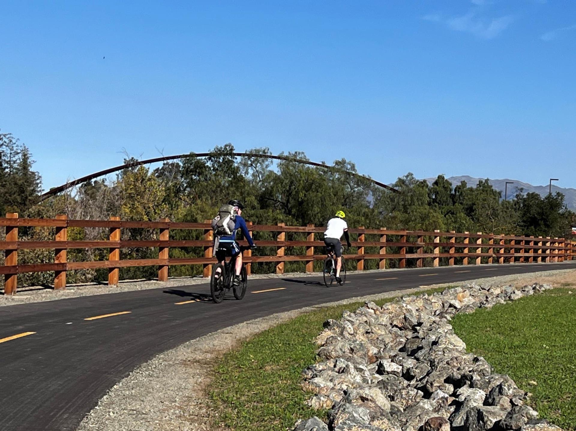 Two bike riders biking on a trail