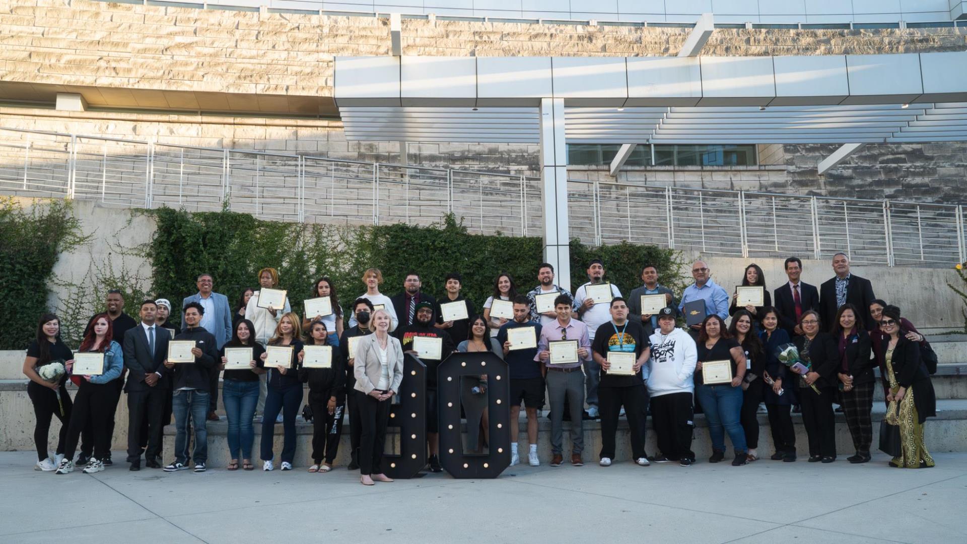 Clean Slate graduates with their diplomas, along with friends, family and City staff stand in front of City Hall.