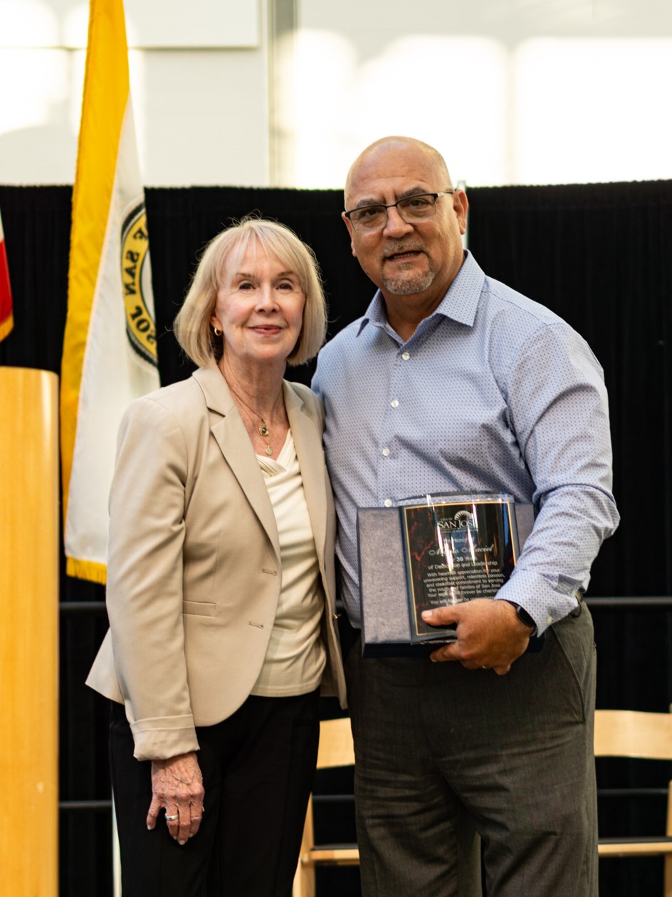 Benson (left) next to Maciel (right) as he cradles his award.