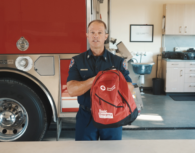 A firefighter holding an emergency go kit.