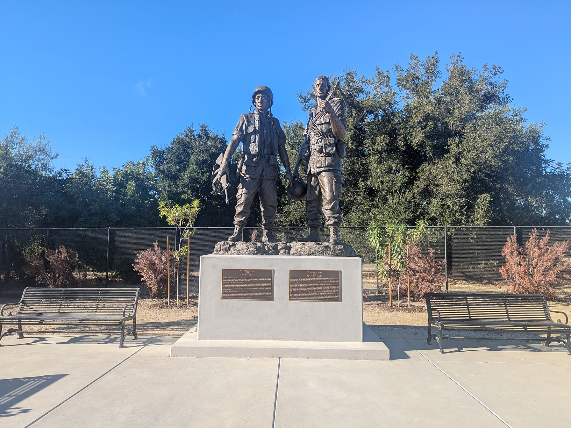 Wide shot photograph of exterior bronze sculpture of two figures