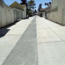 A long wide alley way recently paved with permeable pavers running along the middle