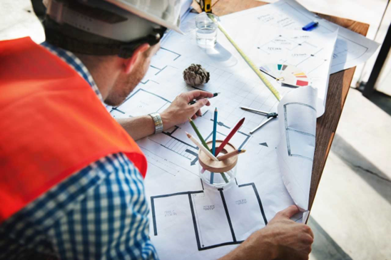 Construction worker looking at blue prints/